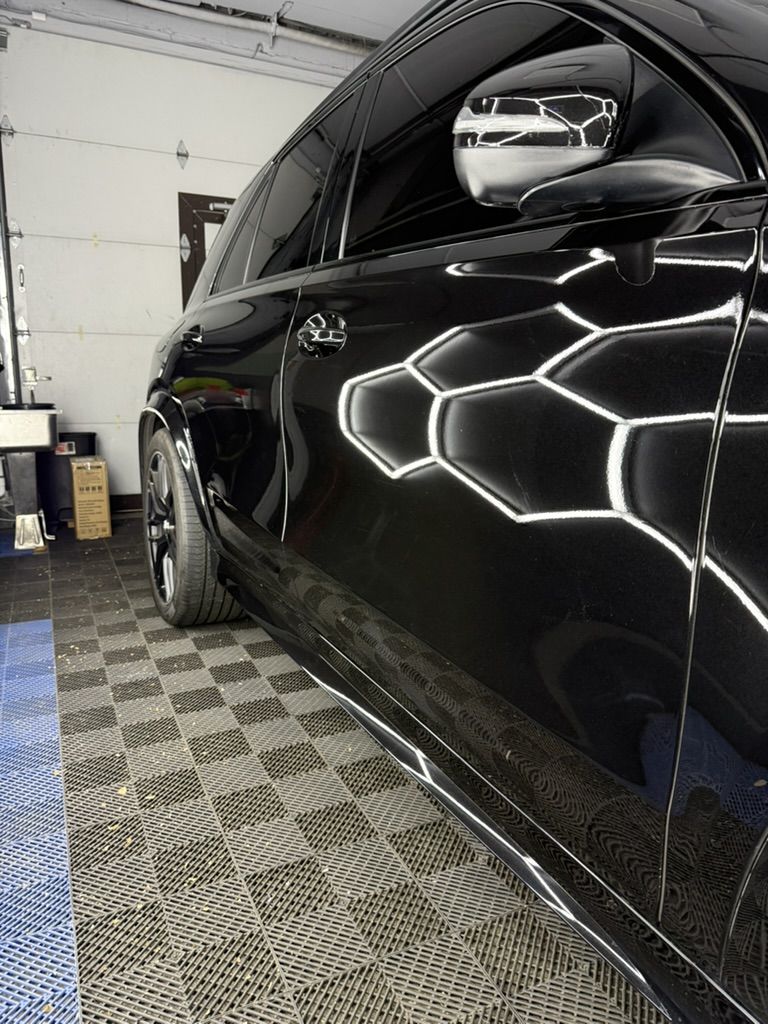 Side of a black Mercedes-Benz GLE reflecting the studio lights