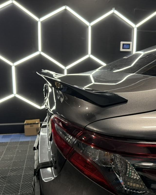 Gray Toyota sedan under the studio hexagon lights